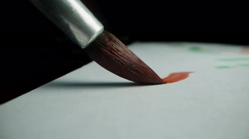 First-person view, macro shots of the artist's brush, painting with red paint on a black background.
