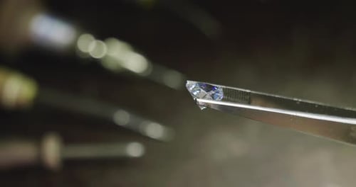 Close up of a goldsmith looking and showing a precious diamond. Concept: Gold, silver, jewelry