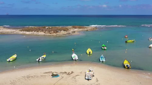 Small Fishing Boats anchored in a shallow lagoon, with packed Fish net onboard, Aerial view