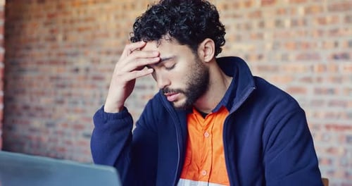 Architect, headache and stress with laptop for safety issue or building delay on construction site