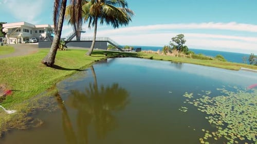 Beautiful FPV drone shot of a path on a lush green park without any people insight leading up to a v