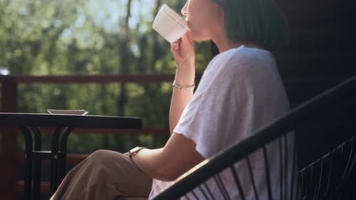 Young Sipping Woman Drinksenjoys Morning Coffee on Terrace of Cozy Wooden House