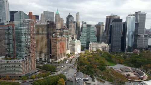 Aerial view away from tall buildings in the lower Manhattan cityscape, New York - pull back, drone s