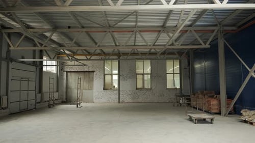 An Empty Bright Industrial Room with Metal Trusses During the Renovation