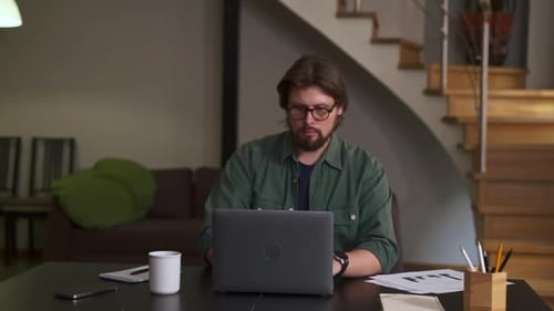 Man Working on Laptop at Home Office Desk