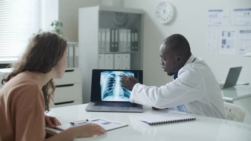 Doctor Explains X-Ray to Patient in Office