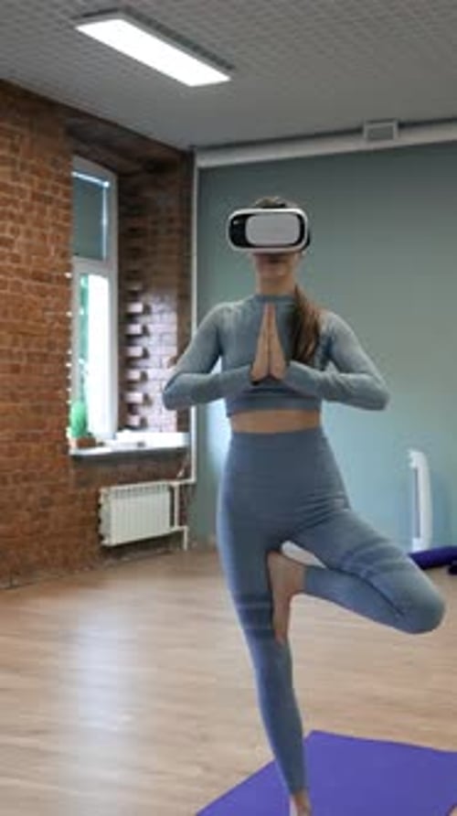 Vertical d'une femme portant des lunettes VR apprend à faire des exercices de yoga avec un entraîneur