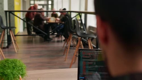 Camera Flies Around Developer Writing Program Code on Computer Display Alone in Office Freelancer