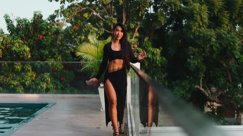 Confident Asian Woman Walking By the Pool in a Luxury Villa