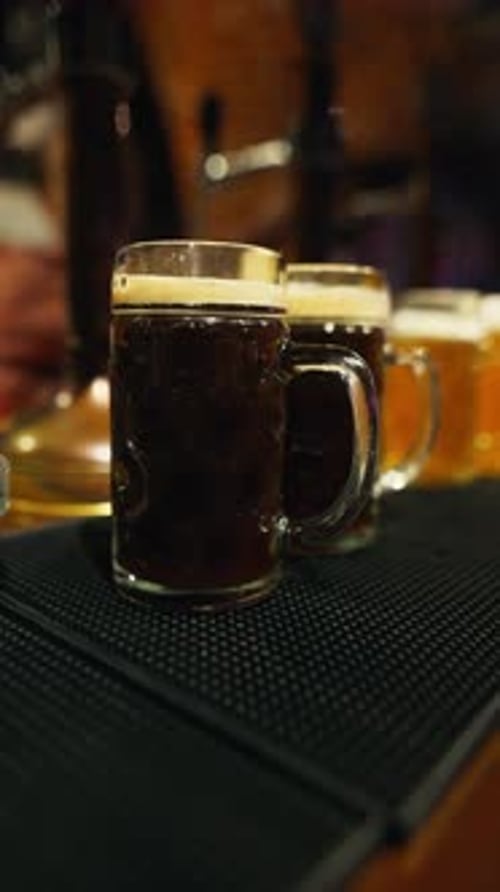 Nahaufnahme von dunklen Biergläsern in einer gemütlichen Bar, perfekt für geselliges Beisammensein und Entspannen mit Freunden