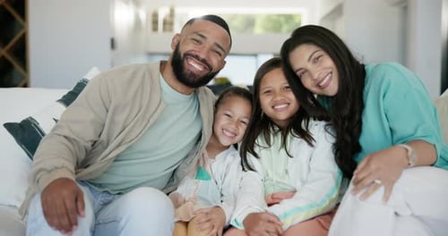 Happy Family Smiling Together on Living Room Sofa