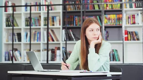 Kaukasische Studentin studiert in Bibliothek