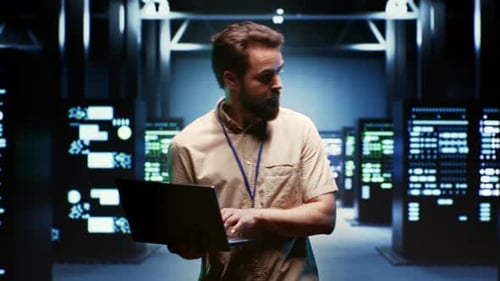 Man with Laptop Working in Server Room