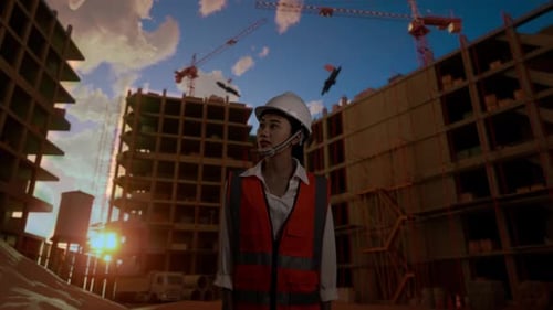 Asian Female Engineer Looking Around At Construction Site