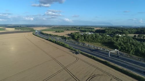 Establishing Drone Shot of Combine Harvester next to Motorway on Sunny Day at Golden Hour in Yorkshi