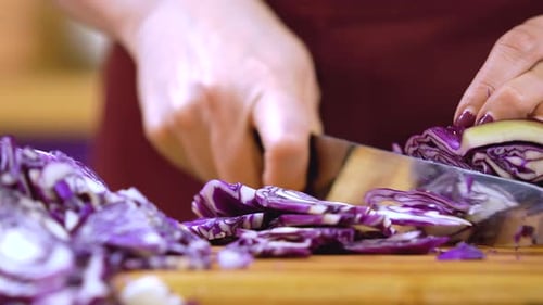 Frau schneidet Kohl. Gemüsesalat kochen.