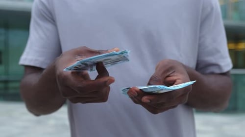 Main d'homme tenant des billets d'un dollar dans une rue urbaine, mains d'homme d'affaires en plein air comptant