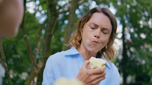 Woman and Child Enjoying Fresh Apples in Nature