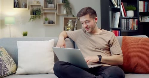 Man Using Laptop on Couch Indoors