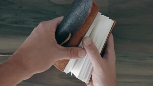Opening vintage leather notebook point of view in slow motion