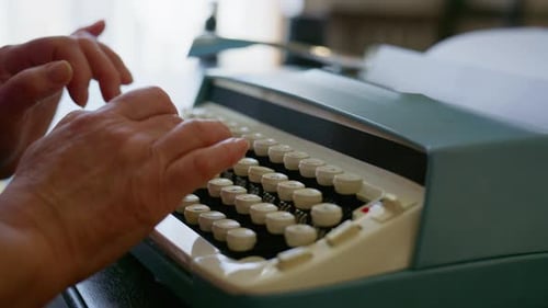 Close Up View of Elderly Woman Typing on Vintage Typewriter
