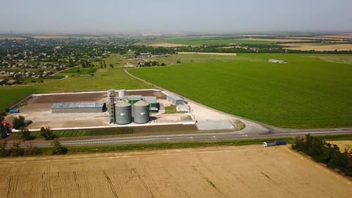 Vue aérienne d'un élévateur à grains devant un champ de blé, drone quadricoptère, caméra volant autour de la farine ou de l'huile
