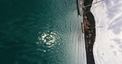 Vertical FPV drone fly over turquoise water bay with sailing boats, Mallorca
