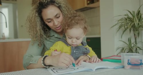 Child Coloring with Adult Companion Indoors