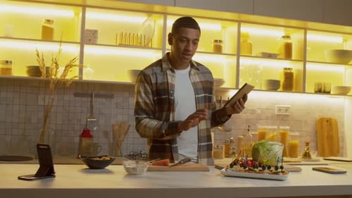 Man Cooking with Tablet in Bright Modern Kitchen