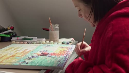 Female with brush drawing. Paint by numbers close up.