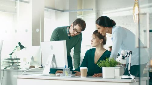 In Brightly Lit and Modern Creative Bureau. In Foreground Three People Discuss Business Issues Usin