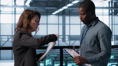Data Center Team Examines Paperwork Files in Server Room Reviewing System