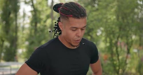 Tired African American Athlete Restores Breathing and Rests After Jogging Outdoors