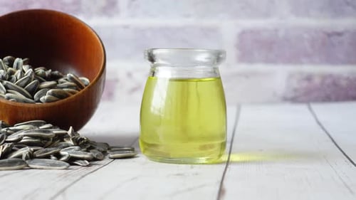 Sunflower Oil Seed and Oil in a Container on Table