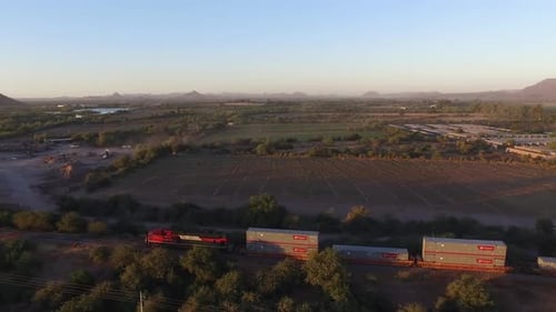 Freight Train Moving Through Rural Landscape