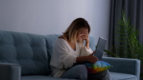 Woman Feeling Stressed While Using Laptop at Home