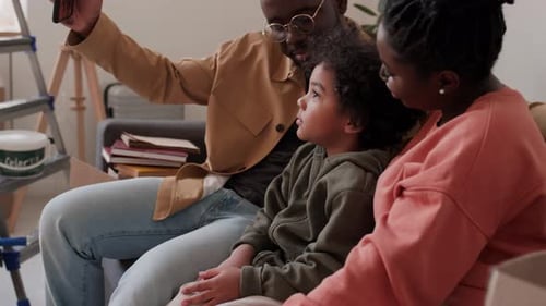 Family taking selfie on sofa