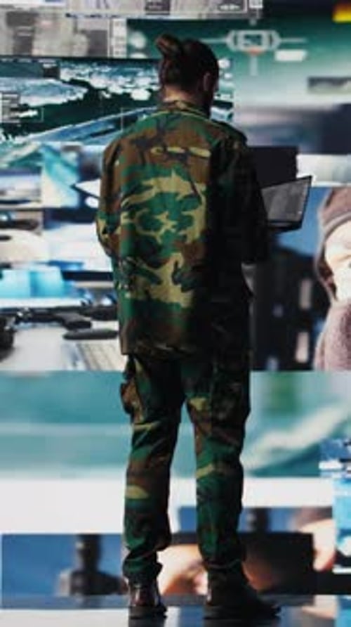 Man in Camo Uniform Stands with Laptop