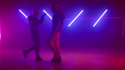 Teenagers dancing in a room with neon lights