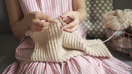 Close up woman knitting woolen clothes with needles a handmade hobby