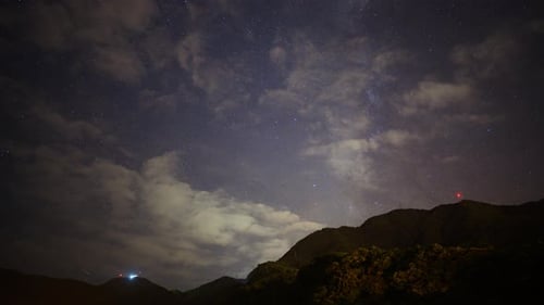 The Milky Way is clearly visible once the fast-moving white clouds disappear.