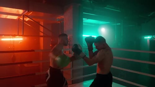 Zwei Boxer-Silhouetten kämpfen im Ring