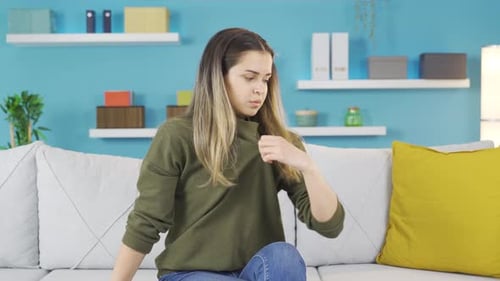Young Woman Cooling Off on Sofa at Home