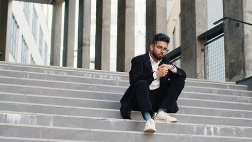Man in Suit Sitting on Urban Stairs
