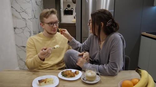 Couple Sharing Food and Drinks at Breakfast Table