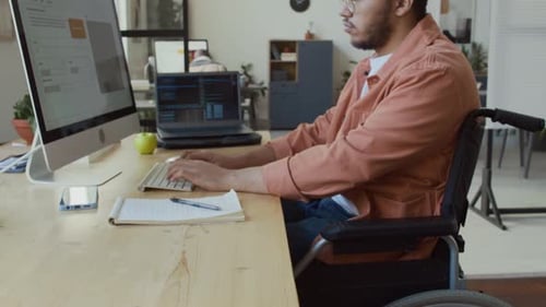 Desarrollador masculino de Oriente Medio en silla de ruedas trabajando en el Código en Office