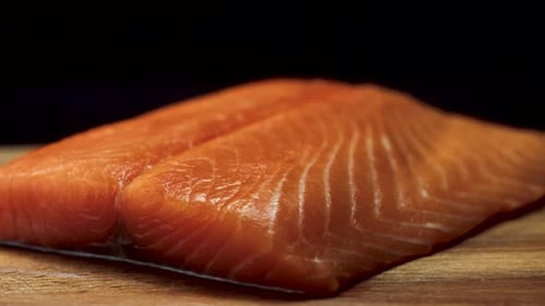 A Delicious and Fresh Salmon Fillet Beautifully Positioned on a Traditional Wooden Cutting Board