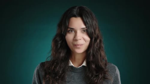 Menina morena faz uma careta divertida para a câmera e mostra a língua