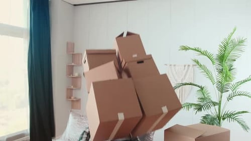 Young Clumsy Arabian Man with Cardboard Boxes in Hands Falls on Sofa and Laughs