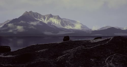 Scenic View of Rugged Mountains Reflecting on Calm Waters at Dusk